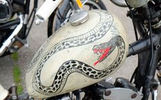 a close up of a motorcycle with a snake painted on it