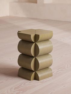 a stack of three wooden stools sitting on top of a hard wood floor