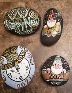 three painted rocks that say happy new year