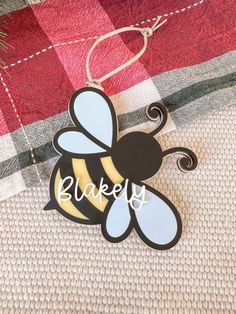 a wooden ornament with the word bakery on it sitting on a plaid blanket