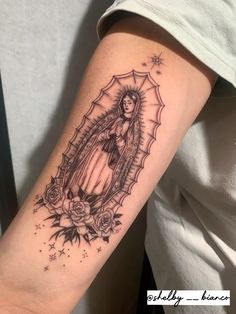 a woman's arm with a tattoo on it that has an image of the virgin mary