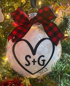 a christmas ornament with a heart and the word s & g on it