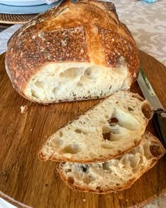 a loaf of bread sitting on top of a wooden cutting board next to a knife