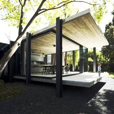 a person standing in front of a house with glass walls and doors on the outside