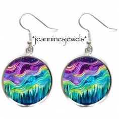 earrings with the image of mountains and stars painted on them in purple, green, blue, and yellow colors