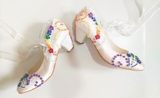 "Rainbow color embellished ivory satin wedding shoes for bride with low heels. These colorful bridal shoes compliment your rainbow wedding theme beautifully! Stay comfortable all night long in these wedding heels, forever keepsake wedding gift as well. Ivory satin wedding shoes are designed with embroidered floral lace appliques. Rainbow color beads, sequins and small pearls are used on the embroidery and organza ribbons tie on the front as bows. They are made of soft smooth satin and delicate lace, each handmade item is unique and can differ in details only slightly. Custom details can be added on this design, soles can be personalized with your names and wedding date. Listing shoe style: 2\" (5cm) heels closed toes in ivory.  See this design in all ivory here: https://www.etsy.com/listin Multicolor High Heel Wedding Shoes, Multicolor High Heels For Wedding, Elegant Multicolor Wedding Heels, Colorful Bride, Lace Wedding Shoes, Rainbow Heels, Wedding Wedges, Satin Wedding Shoes, Bridal Shoes Low Heel