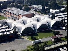 an aerial view of a large white building with lots of windows and roof coverings