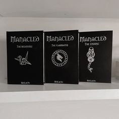 three books sitting on top of a white shelf