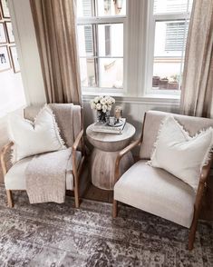 two chairs sitting next to each other in front of a window