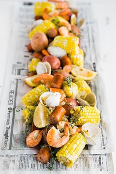 corn, potatoes and shrimp are on the newspaper