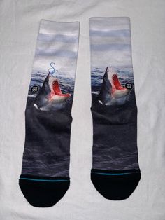 Elevate your sock game with these Stance socks for men. These novelty socks feature a great white shark theme, with Jaws and shark motifs, making them perfect for fans of the iconic movie. The socks are made from a comfortable combed cotton blend material, and come in a crew length and size medium (8-12). The cushioned features of these socks make them ideal for everyday wear, as well as for specific activities like tennis, walking, golf, and even school. With a pack of one pair, these Stance socks are a must-have for any sock collection. Add some style and comfort to your wardrobe with these novelty socks today. Sock Collection, Stance Socks, Sock Game, Socks For Men, White Sharks, Great White Shark, Great White, Novelty Socks, Iconic Movies