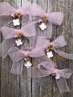 pink and gold bracelets with bows on wooden background, close up view from above