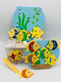 an assortment of colorful fish on display in front of a blue box with yellow handles