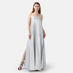 Chic, comfortable and edgy, this silver strapless pleated maxi dress offers a highly flexible fit with an adjustable button closure at back. Dress comes in ankle length or floor length, refer to size guide for dress length. High rise pleating, gold button details, and a stylistic belt tie at the bust add flare to the designs minimalist charm. The medium weight fabric, cruelty free vegan leather, has a loosely structured drape for a relaxed and remarkably comfortable fit. You'll be kept warm in c Chic Luxury Metallic Maxi Dress, Luxury Silver Sleeveless Maxi Dress, Mettalic Pleated Dress, Luxury Metallic Strapless Dress, Pre-draped Pleated Silk Maxi Dress, Silver Maxi Dress, Designer Maxi Dress, Eve Dresses, New Years Eve Dresses