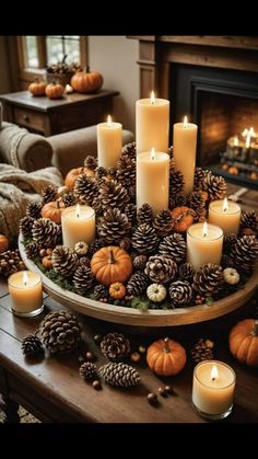 candles and pine cones are arranged in a circular arrangement on a table near a fireplace