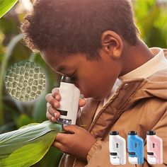 a young boy looking through a microscope at some plants and other things in front of him