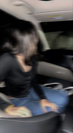 a blurry photo of a woman sitting in a car seat