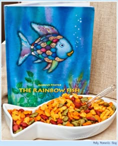 the rainbow fish book is next to a bowl of cereal