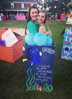 two girls are posing in a box with balloons