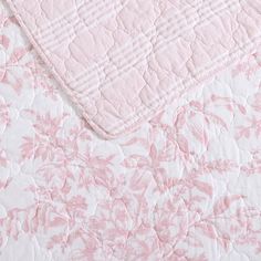 a pink and white floral quilted bed spread