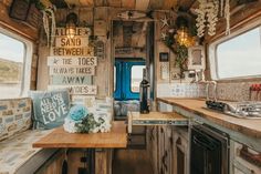 the interior of an rv is decorated with flowers and signs on the walls, along with wood countertops