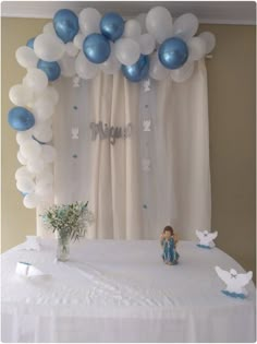 a table with balloons and decorations for a baby's first birthday party on it