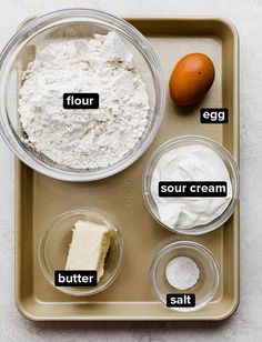 ingredients to make an egg and cheese cake on a baking tray with the words flour, sour cream, butter, salt, eggs