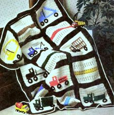 there is a crocheted blanket that has cars on it and trucks on it