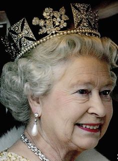 an older woman wearing a tiara and smiling at the camera with words rest in peace queen elizabeth