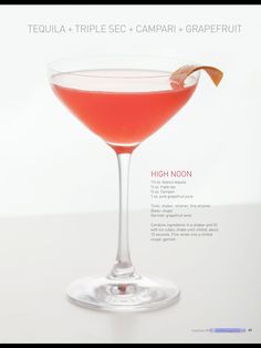 a red cocktail in a coupe glass with a garnish on the rim