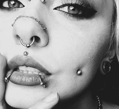 a woman with piercings on her nose and nose ring in black and white photo