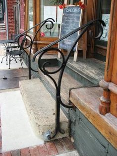 an iron hand rail on the outside of a restaurant