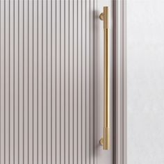 a close up of a door handle on a white door with vertical slats in the background