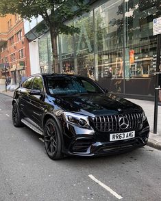 a black mercedes gle is parked on the side of the street