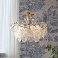 a chandelier hanging from a ceiling in front of a wallpapered background