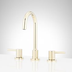 the modern faucet with two handles is shown in gold