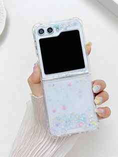 a woman holding up her phone case with glitter on the bottom and side, while she is