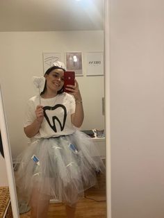 a woman is taking a selfie in the mirror wearing a t - shirt and tutu