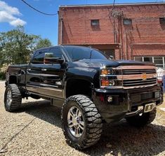 a black truck parked in front of a brick building