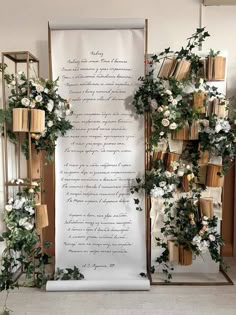 a large scroll decorated with flowers and greenery next to an open bookcase filled with books