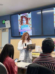 a woman standing in front of a group of people