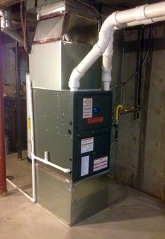 an air conditioner in the middle of a room with pipes and wires on it