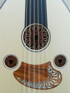 a close up view of the strings on a white and brown guitar with an intricate design