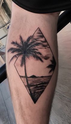 a man's leg with a palm tree tattoo on it