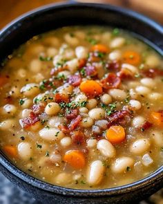 a black bowl filled with beans and bacon