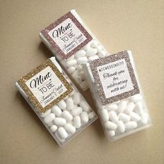 three small candy bags filled with white and gold marshmallows next to each other