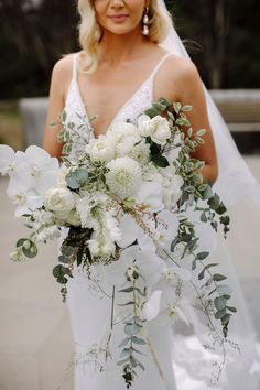 a bride holding a bouquet of white flowers