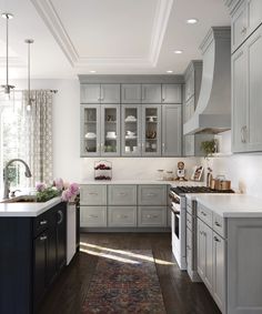 a large kitchen with gray cabinets and white counter tops, along with an area rug on the floor