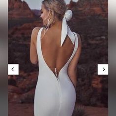 the back of a woman's white dress in front of mountains and desert scenery