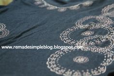 a close up view of a blue shirt with white designs on the front and back